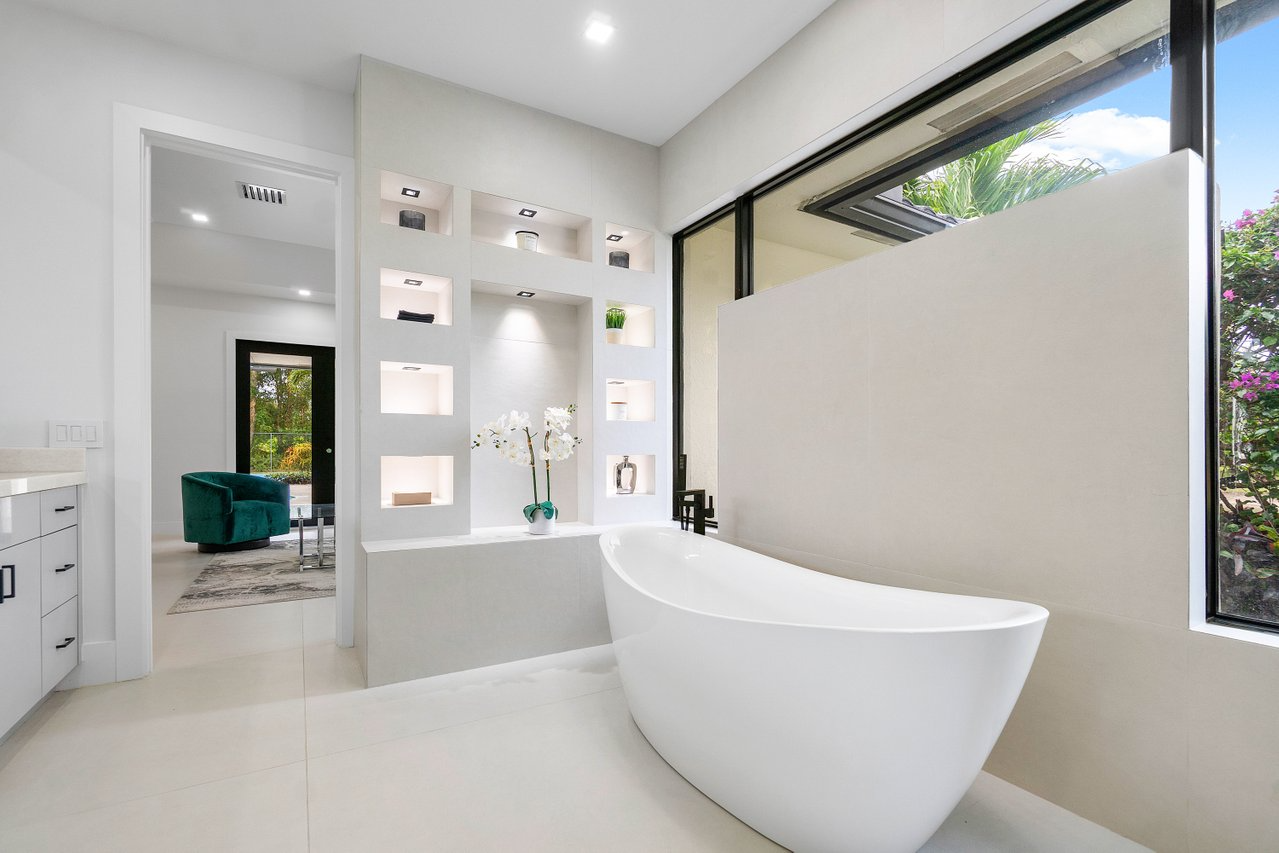 Modern bedroom with stone accent wall and tropical view