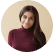 Smiling woman with long dark hair in a burgundy top.